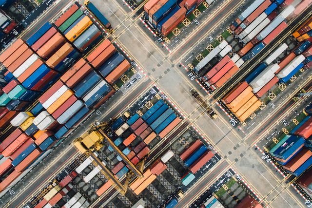 A shipping yard from above,
with rows of colorful stacked shipping containers